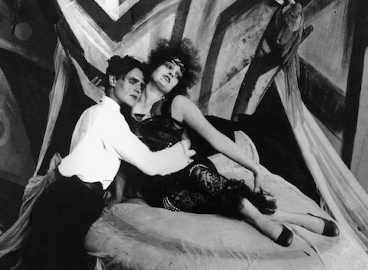 Hans Heinrich von Twardowski and Fern Andra reclining on a divan against angular painted Expressionist flats, in Robert Wiene's Genuine (1920)