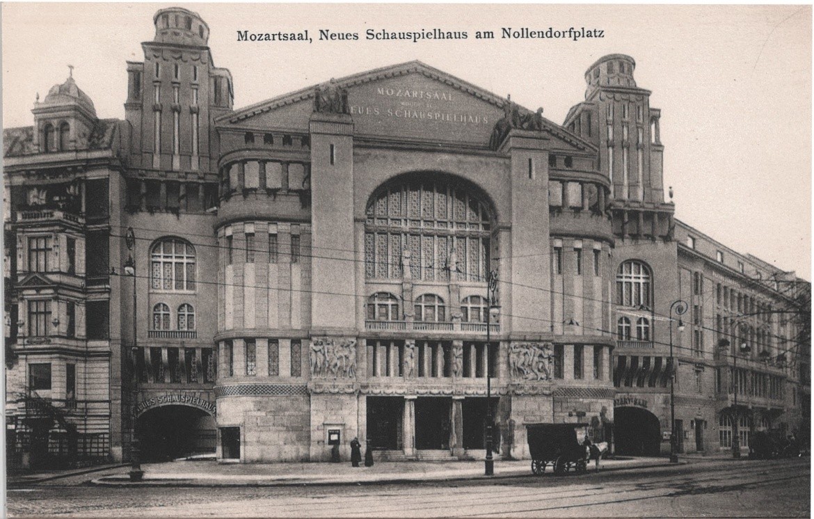 Photographic postcard captioned "Mozartsaal, Neues Schauspielhaus am Nollendorfplatz": a large ornate theatre on a street corner, with twin towers flanking a tall arched window and a horse-drawn cart at the kerb